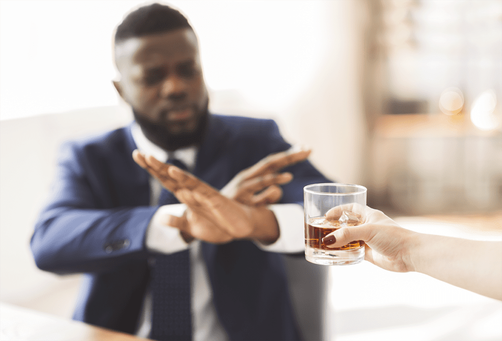 man refusing an alcoholic drink, sober new years