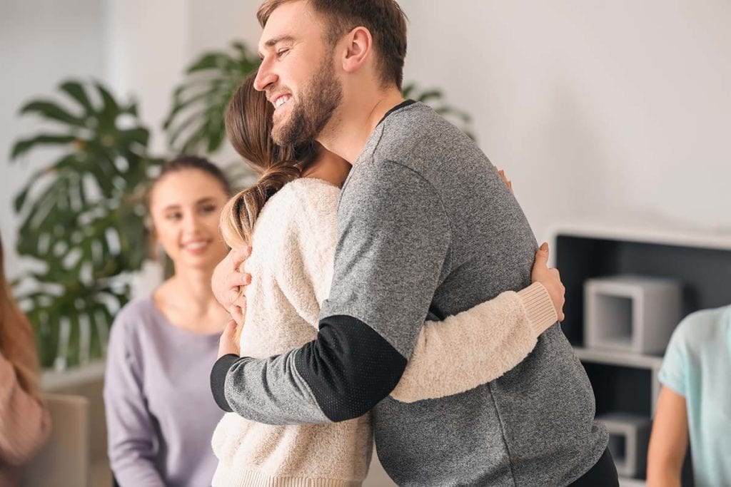 patients hugging experiencing the benefits of group therapy