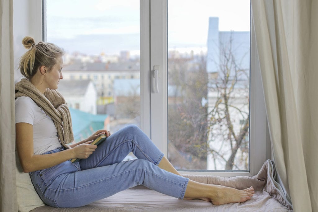 woman sitting at a windowsill wonders about mental disorders from drug use