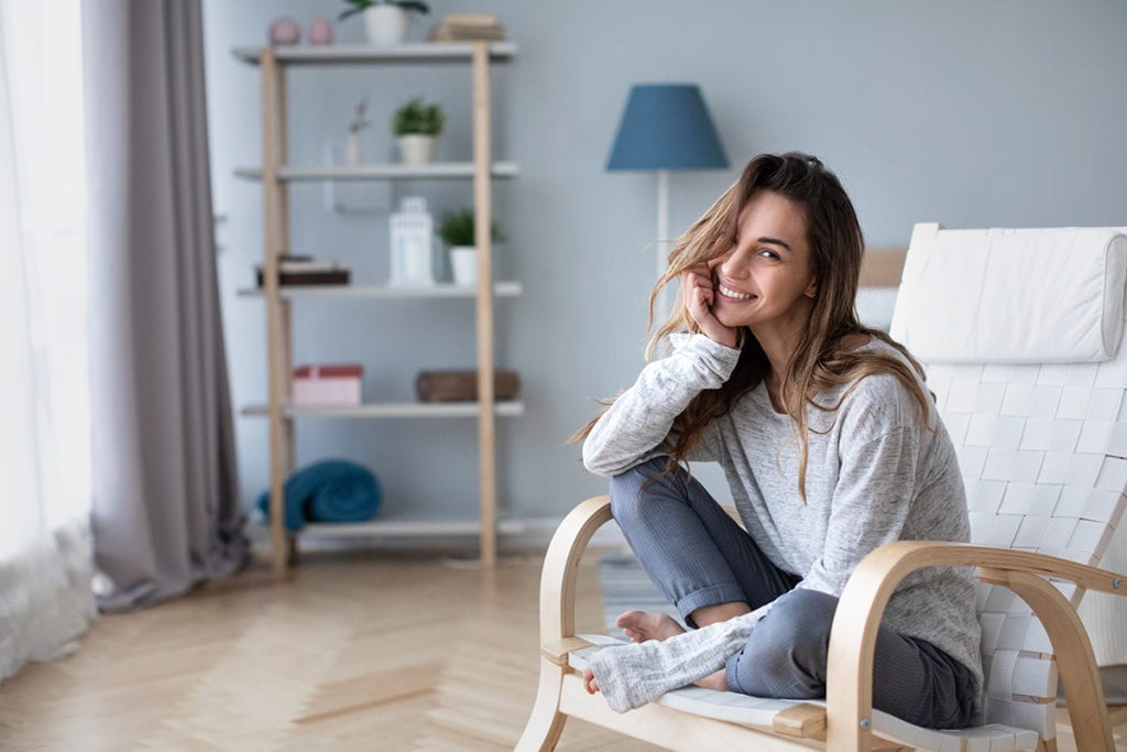 woman in chair smiling Staying sober during Coronavirus