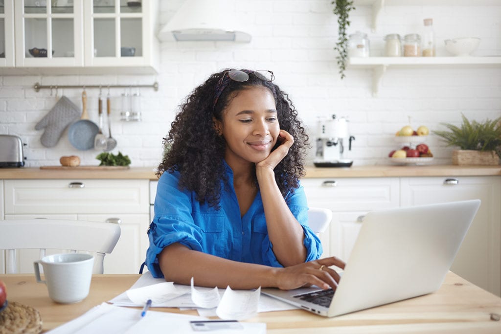 woman surfing the internet in kitchen coping with loneliness during quarantine