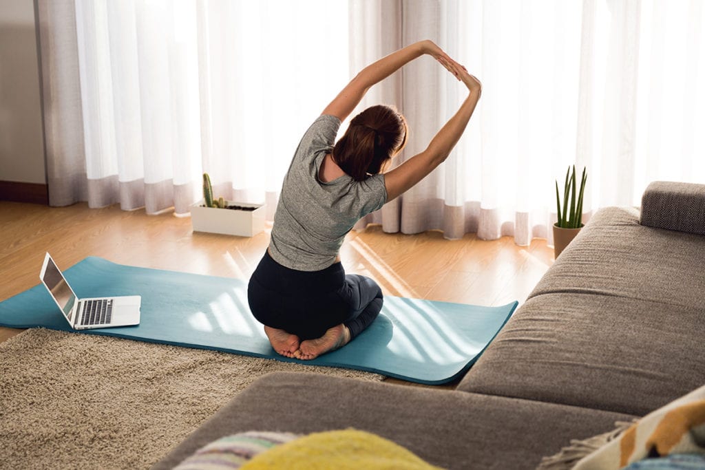 woman doing yoga showing how to fill your time sober in quarantine