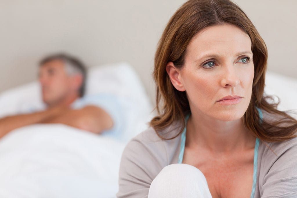 woman sitting on bed worried about Loved One with Depression