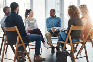 People sitting in a circle at a group therapy program