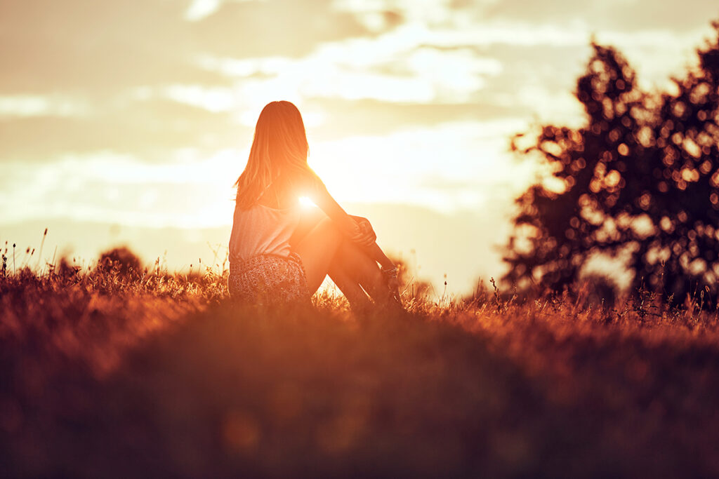 Person outdoors in the sun, thinking about powerlessness in recovery