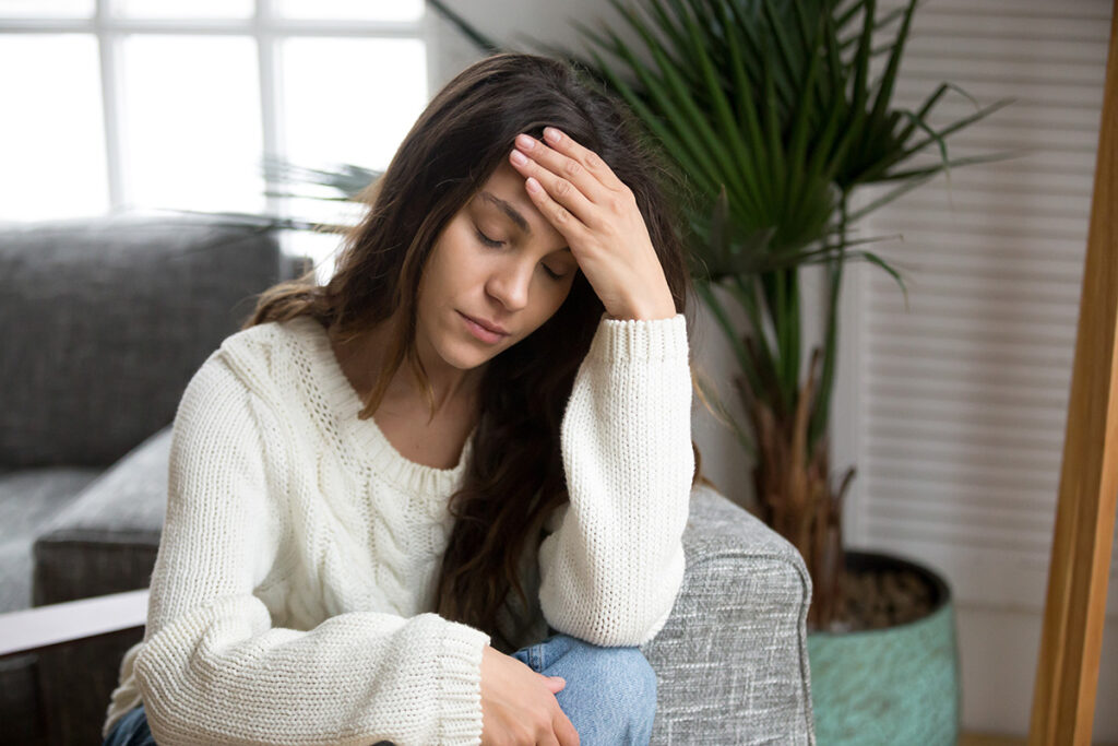 A woman is sitting with her hand to her head. She's worried about how long cocaine is going to stay in her system.